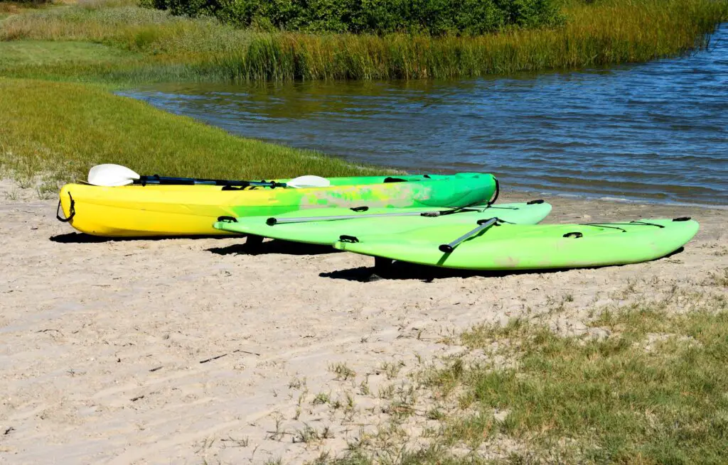 Three kayaks on a riverbank